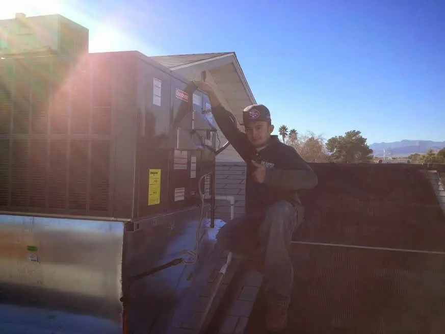 HVAC technician performing Air Duct Cleaning on a rooftop unit in Cheshire